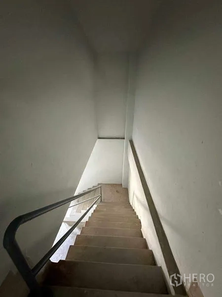 Warehouse for rent in Mueang Samut Sakhon, Samut Sakhon - Enclosed stairwell with metal handrail descending to the warehouse floor.