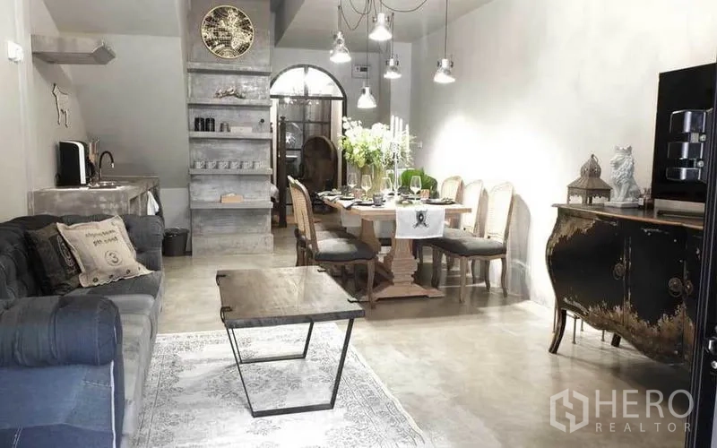 Townhouse for rent in Watthana, Bangkok - Open-plan living and dining space with polished concrete finishes and pendant lights.