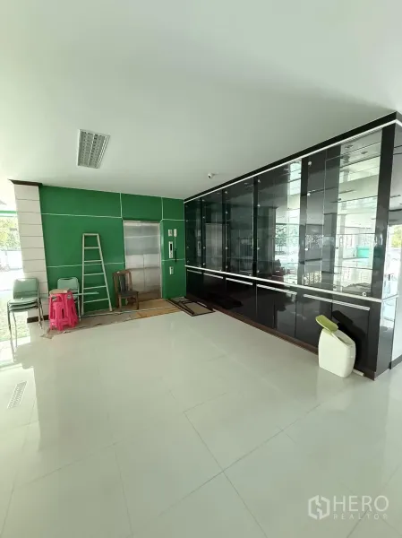 Warehouse for rent in Mueang Samut Prakan, Samut Prakan - Ground-floor lobby showing a service lift and glass display cabinets.
