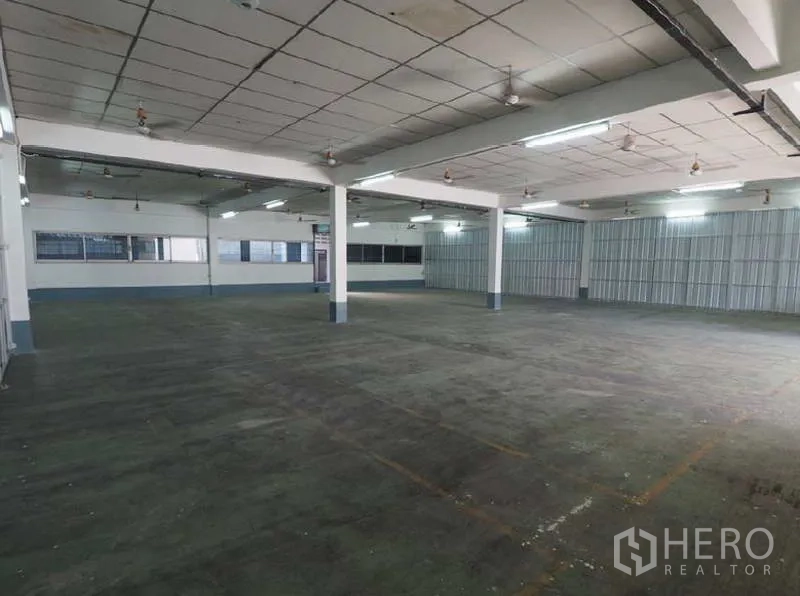 Warehouse for rent in Bang Kapi, Bangkok - Large open storage floor with high ceiling, metal panel walls and ample overhead lighting.