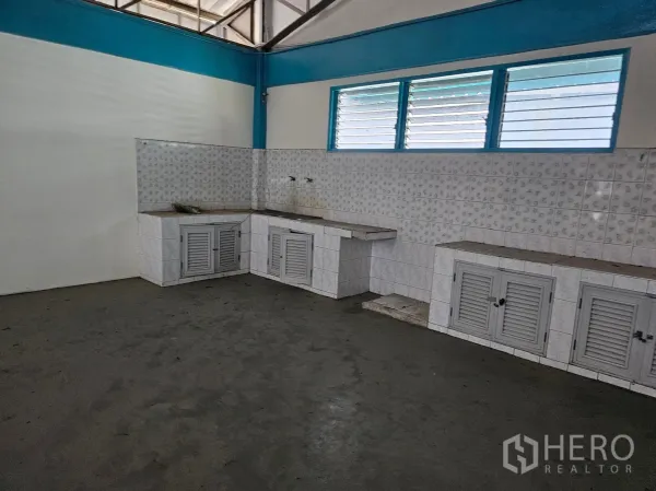 Factory for rent or sale in Mueang Rayong, Rayong - Staff pantry area with tiled counters, backsplash and louver windows inside the factory.
