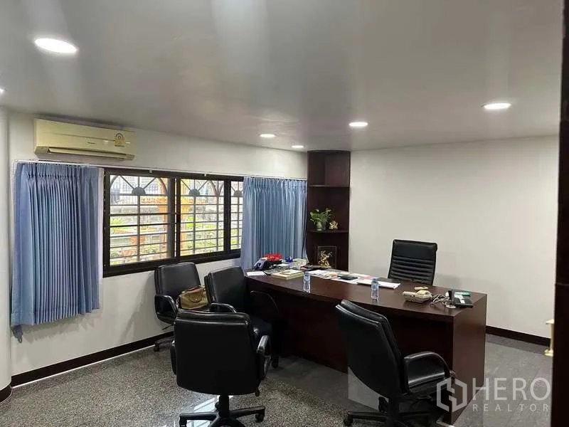 Factory for rent or sale in Bang Phli, Samut Prakan - Executive office with large desk, guest chairs, window with blue curtains and air-conditioning.