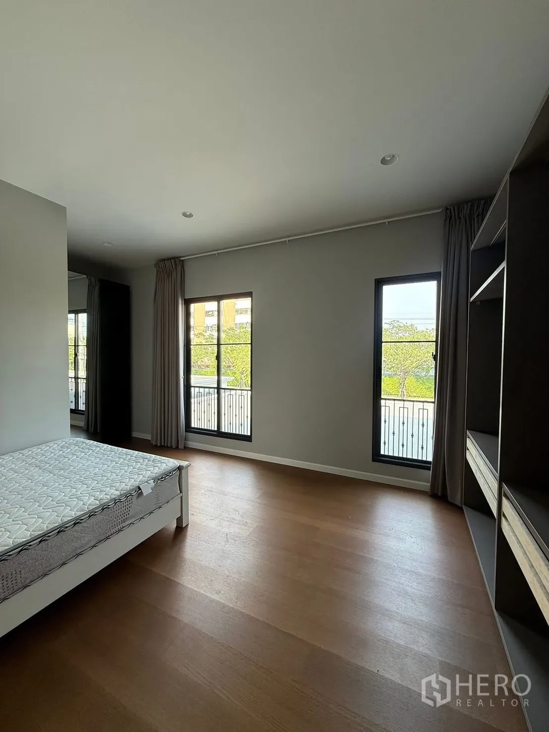 Detached House for rent in Bang Kapi, Bangkok - Bright bedroom with wood floors, large windows, balcony outlook and open wardrobes.