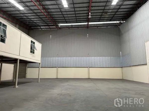 Factory for rent in Bang Phli, Samut Prakan - Spacious warehouse hall with high-clearance ceiling, metal cladding and concrete floor, plus mezzanine offices.