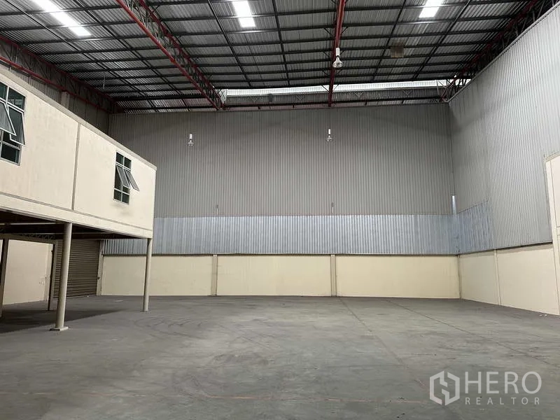 Factory for rent in Bang Phli, Samut Prakan - Spacious warehouse hall with high-clearance ceiling, metal cladding and concrete floor, plus mezzanine offices.