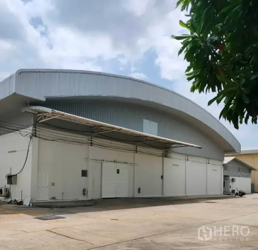 Warehouse for rent in Bang Pa-in, Phra Nakhon Si Ayutthaya - Modern white warehouse with arched metal roof, loading canopies and a wide concrete yard.
