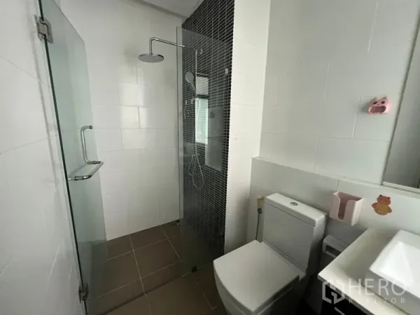 Townhouse for rent or sale in Khlong Toei, Bangkok - Modern bathroom featuring a frameless glass shower and white tiled walls.