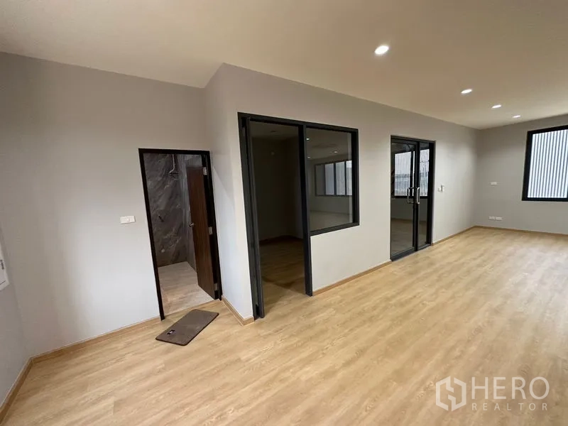 Factory for rent or sale in Lam Luk Ka, Pathum Thani - Office area with glass-partitioned rooms and a nearby tiled restroom.