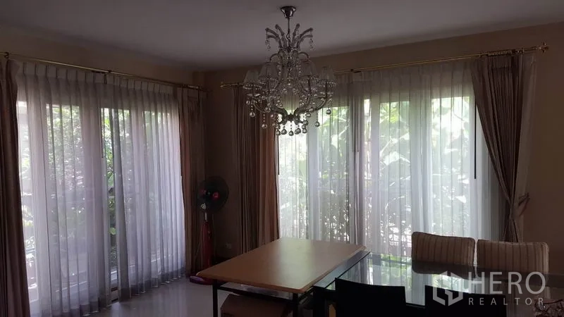 独立式住宅 出售在Mueang Nonthaburi, Nonthaburi - 餐厅区，水晶吊灯、大窗户与玻璃餐桌