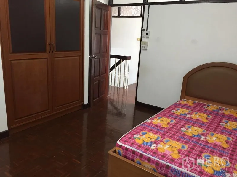 Townhouse for rent in Phra Khanong, Bangkok - Bedroom with parquet floor and built-in wooden wardrobe.