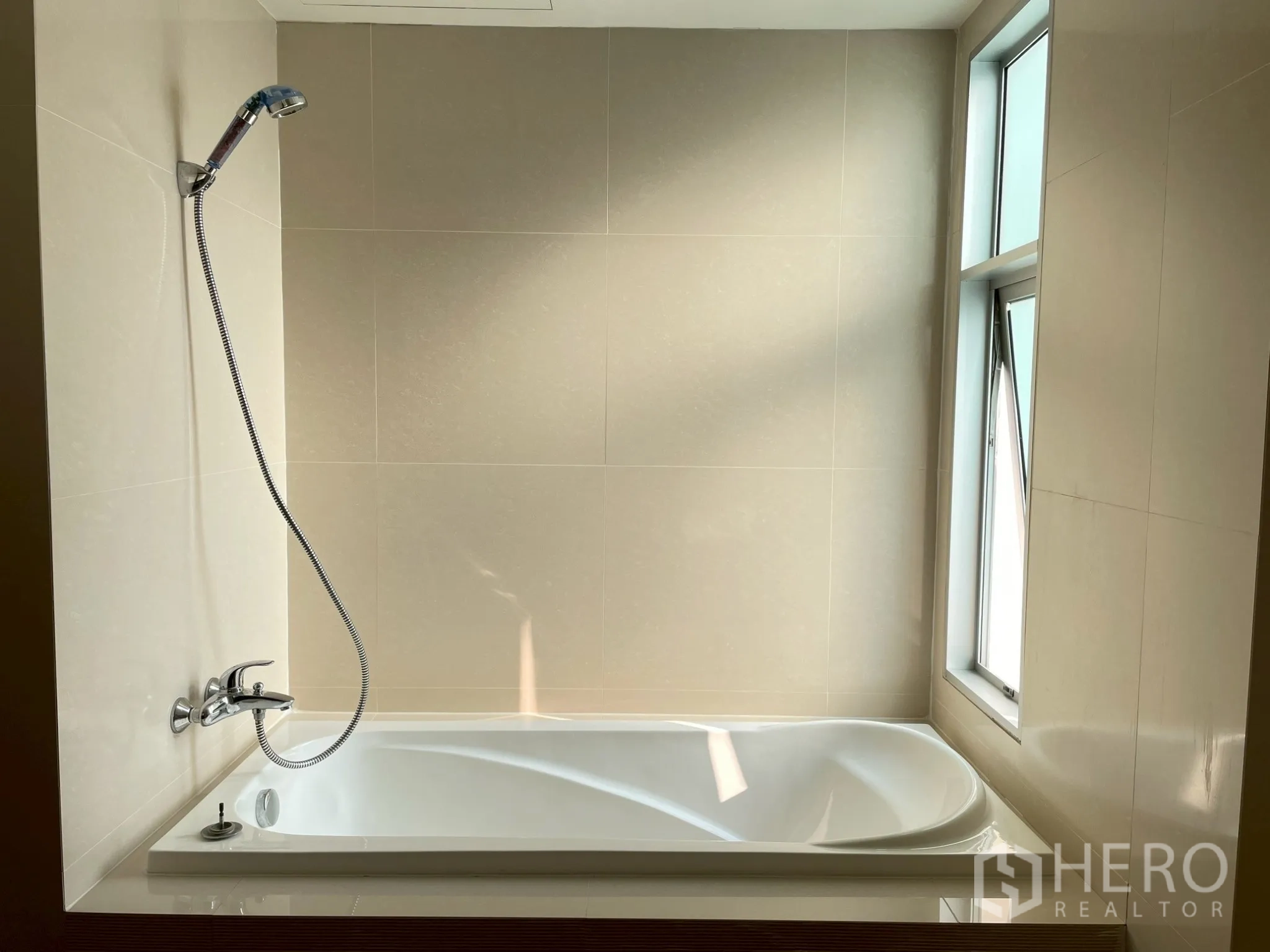 Apartment for rent in Khlong Toei, Bangkok - Bathtub with handheld shower and window for natural light.