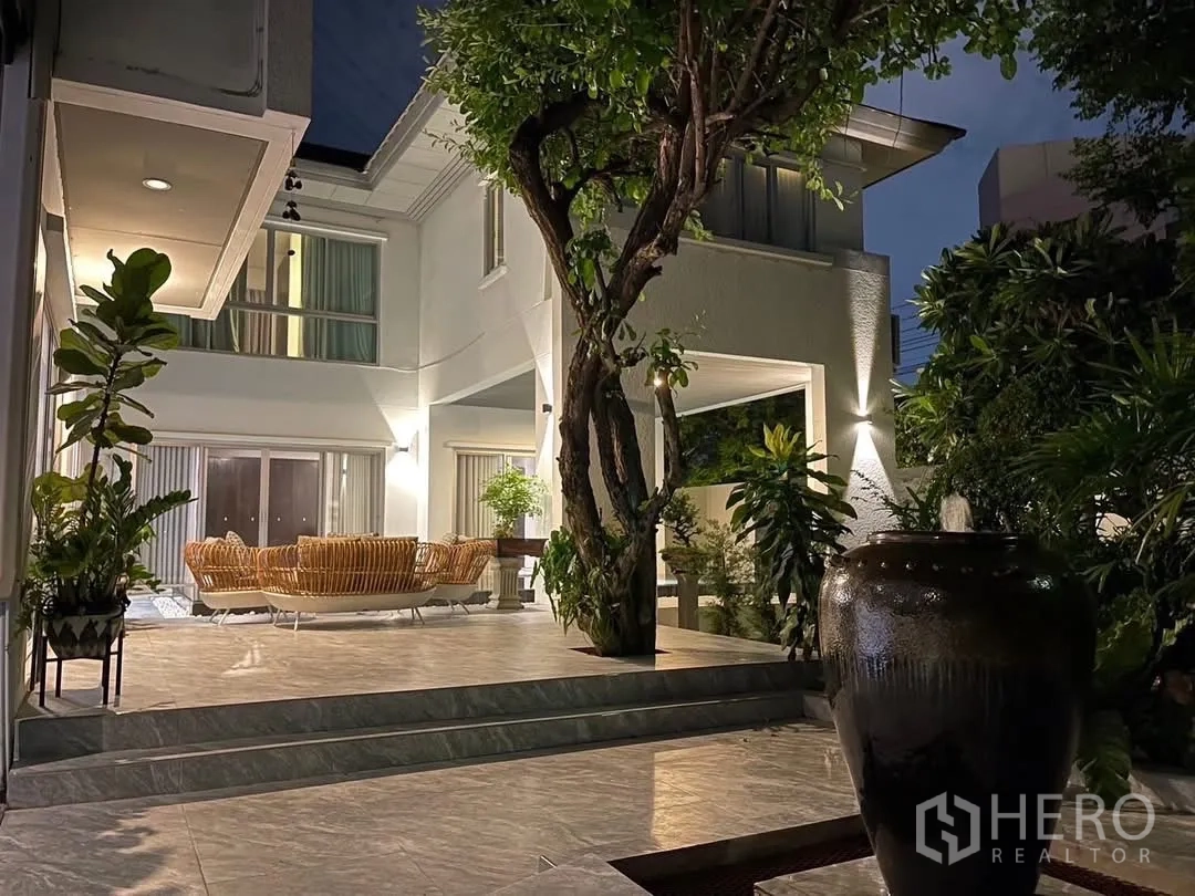 Detached House for rent in Suan Luang, Bangkok - Two-storey house facade and landscaped courtyard in evening light.