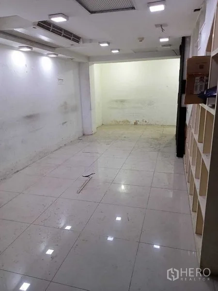 零售空间 出租在Watthana, Bangkok - 下层另一视角，带展示格架、射灯与开阔可用空间。