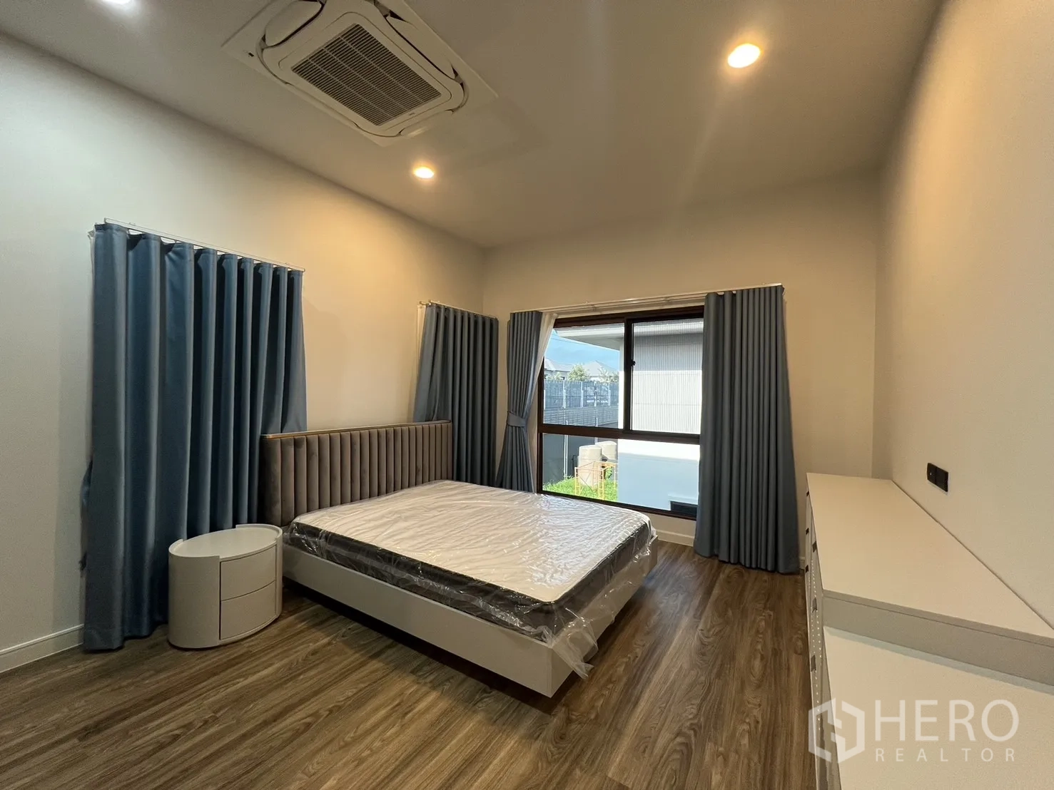 Detached House for rent or sale in Bang Kapi, Bangkok - Large bedroom with upholstered headboard and multiple windows