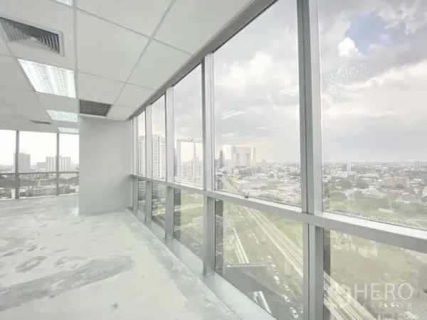 Office Space for rent in Chatuchak, Bangkok - Row of floor-to-ceiling windows inside an office overlooking the Bangkok skyline and elevated rail line.