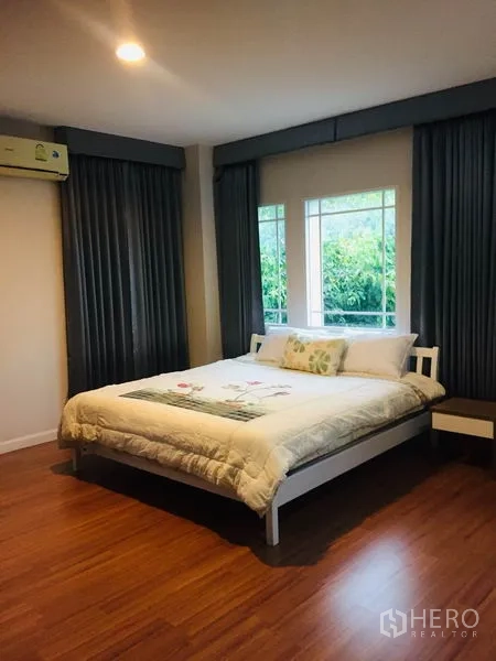 Detached House for rent in Bang Kapi, Bangkok - Spacious master bedroom with wood floors, large windows and soft lighting.