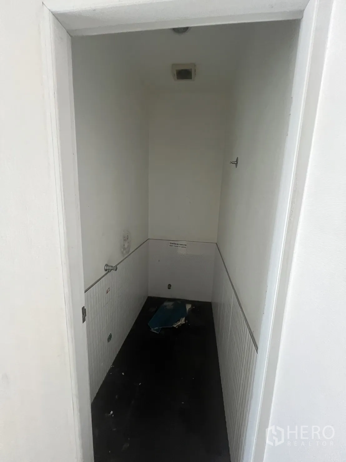 Retail Space for rent in Khlong Toei, Bangkok - Narrow restroom with half-height white tiles and dark flooring.