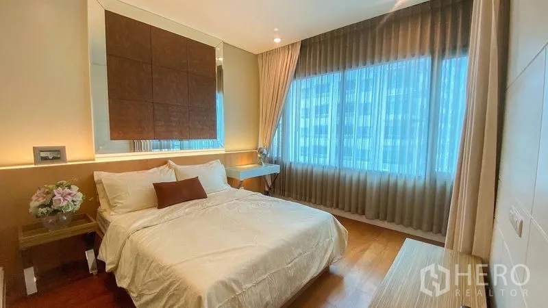 Condominium for rent in Khlong Toei, Bangkok - Third bedroom with big windows, soft curtains and a mirrored decorative panel.