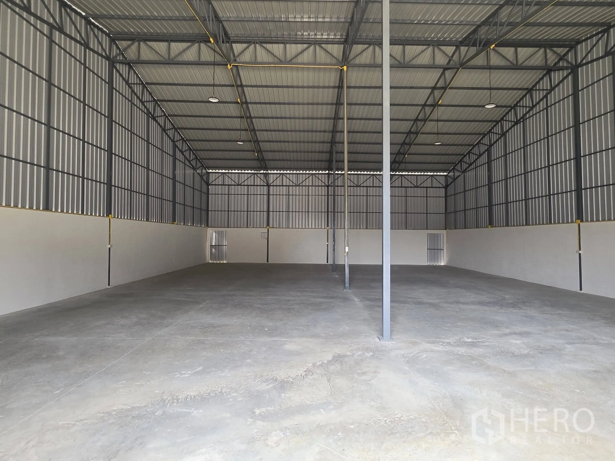 Warehouse for rent in Mueang Samut Prakan, Samut Prakan - Open-plan warehouse interior with bright lighting, high ceiling, and multiple support columns.