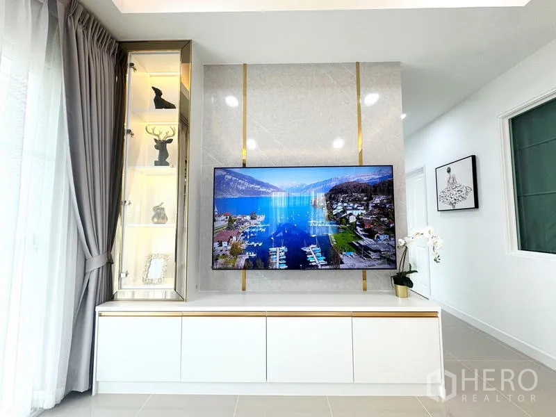 Detached House for rent - Close-up of TV feature wall with display cabinet and gold trim.