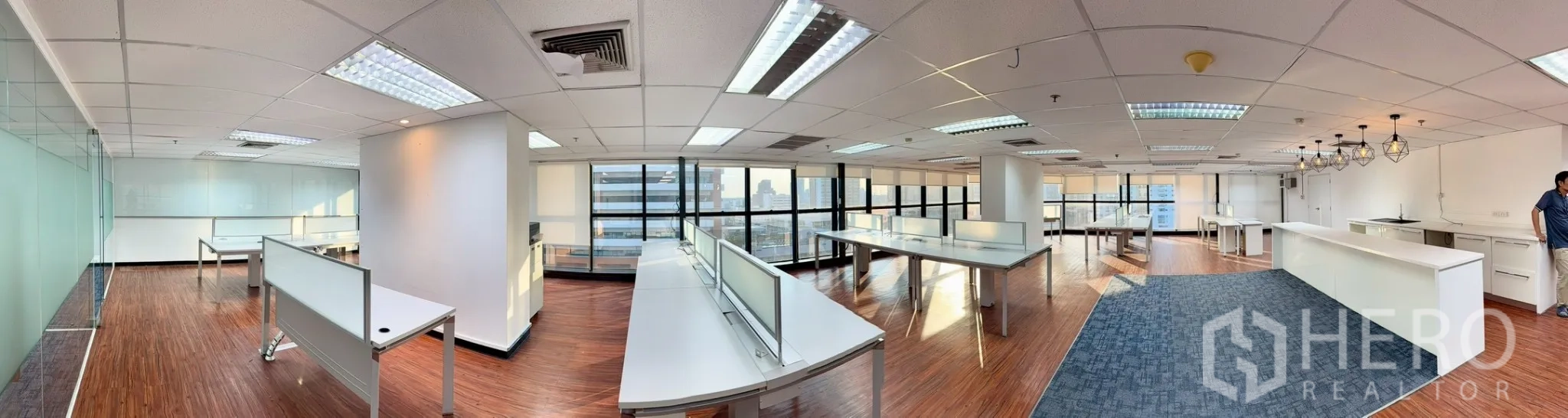 Office Space for rent in Watthana, Bangkok - Panoramic open-plan office with white desks, large windows, wood floors, and city views.