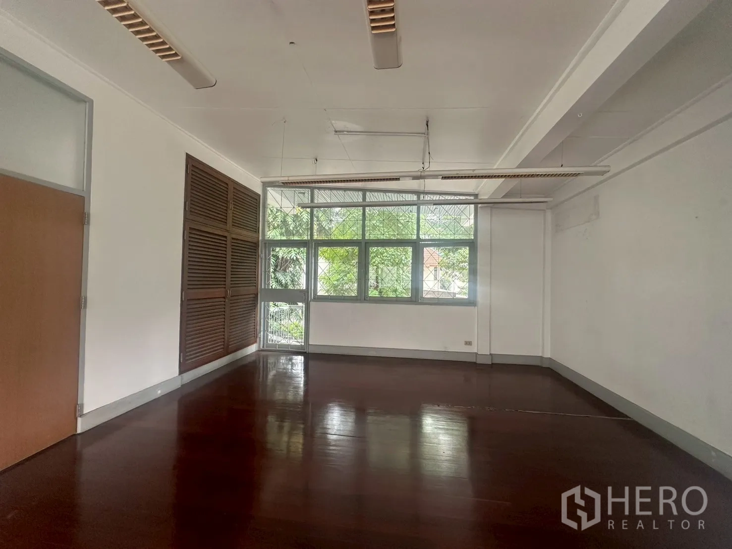 Detached House for rent in Watthana, Bangkok - Upstairs room with louvered cabinets and big windows overlooking trees.