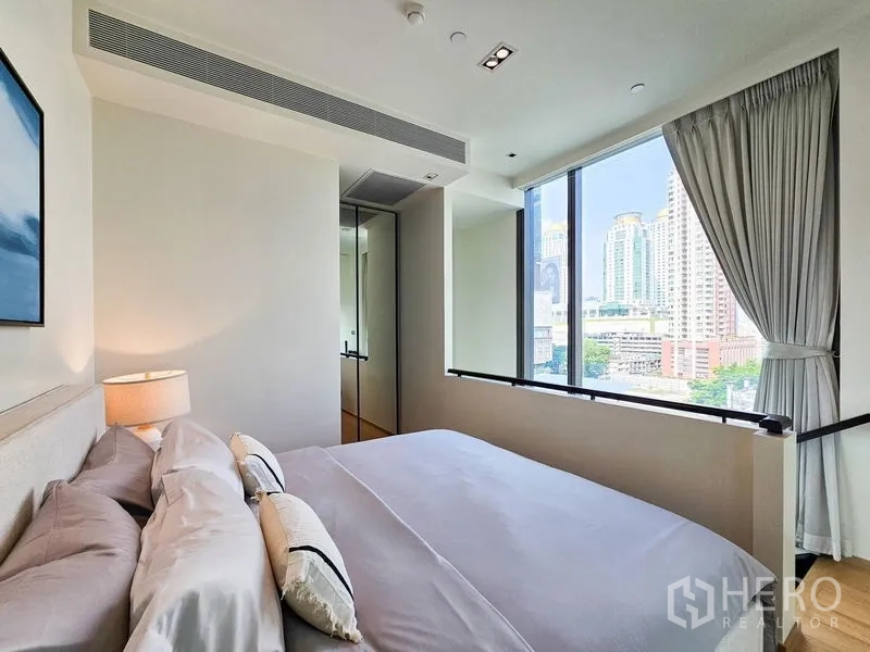 Condominium for rent - Bedroom with large window, city skyline outlook, and built-in wardrobe.