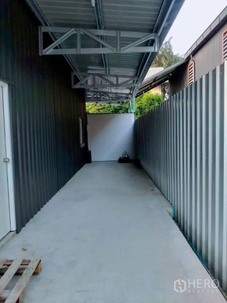 Warehouse for rent in Lat Phrao, Bangkok - Covered side loading bay with metal cladding and concrete walkway beside the warehouse.