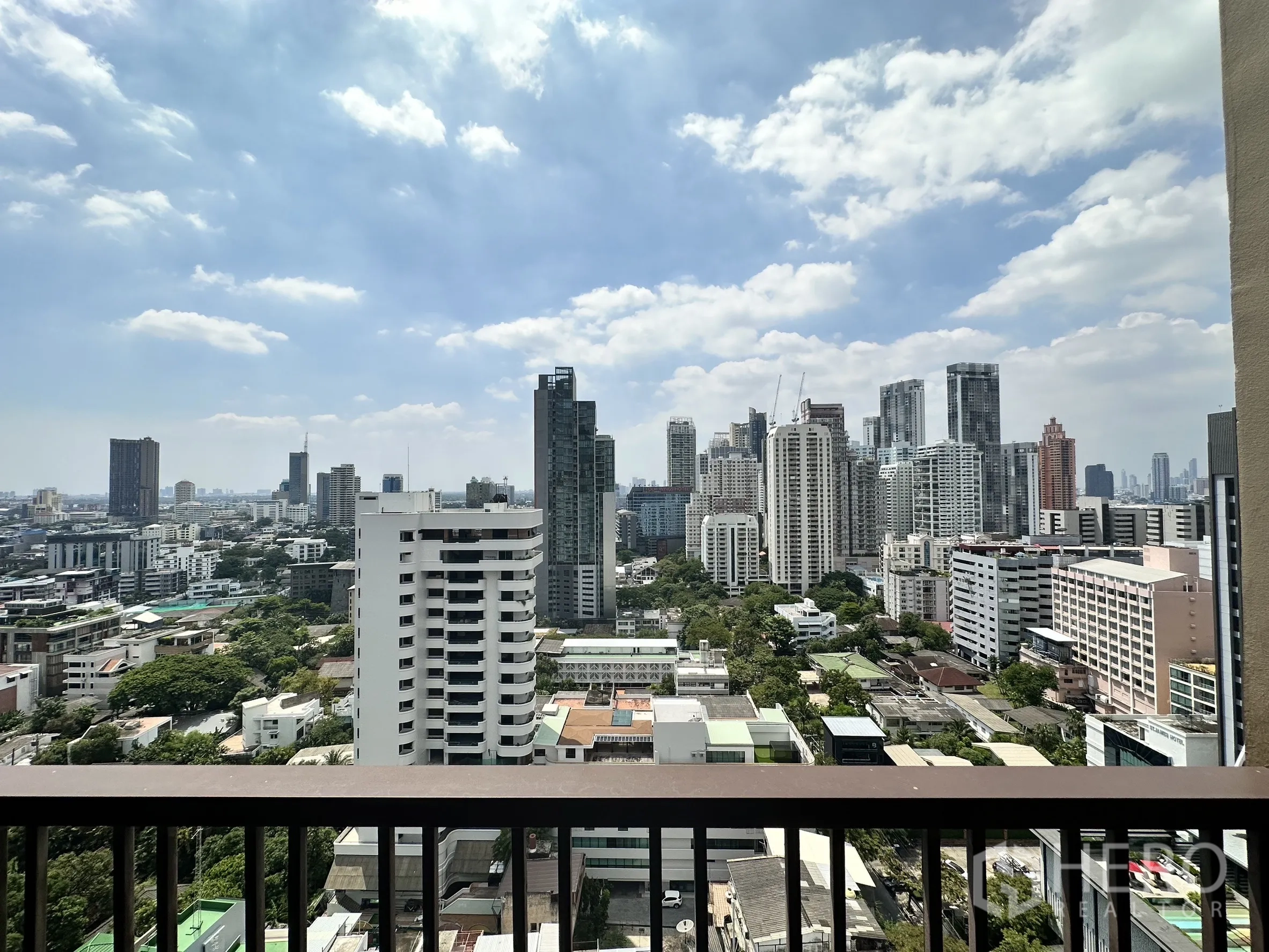 Condominium for rent in Bangkok - Wide skyline view from the balcony with towers under a bright blue sky.
