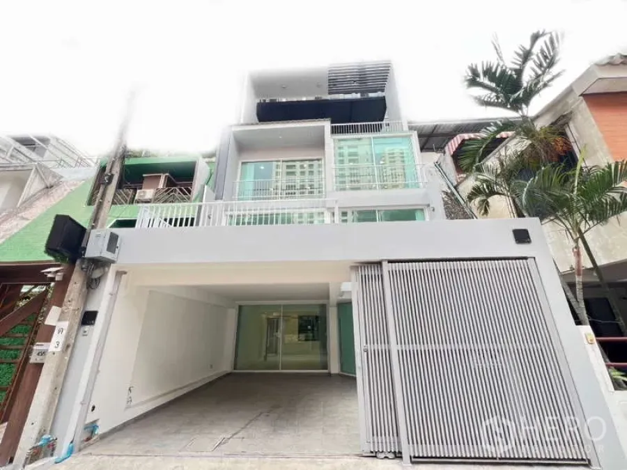 Home Office for rent in Khlong Toei, Bangkok - Street-facing modern townhouse facade with gated parking and balconies.