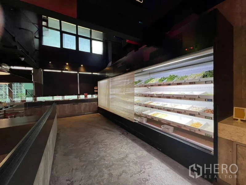 Shophouse for rent or sale in Khlong Toei, Bangkok - Modern restroom with long mirror, twin basins and marble-effect walls.