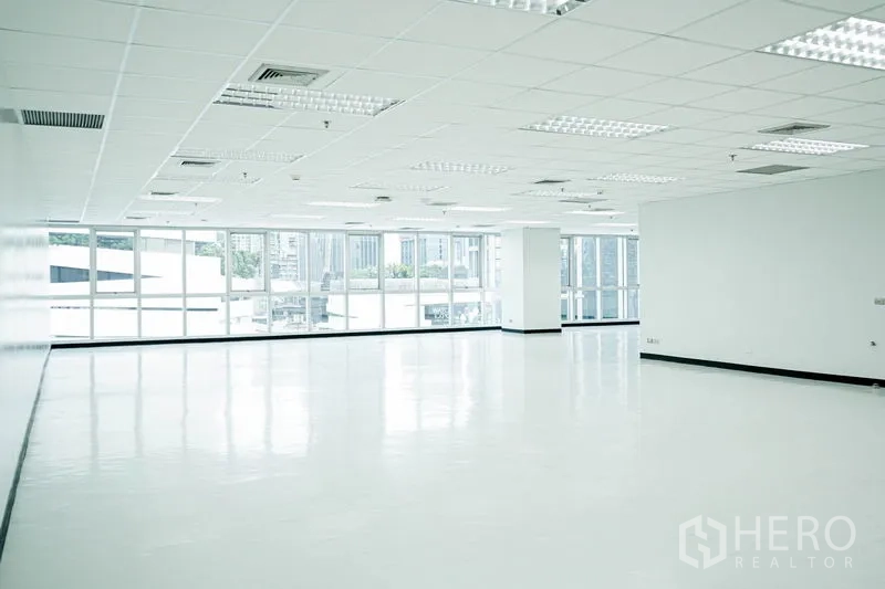 Office Space for rent in Watthana, Bangkok - Sunny corner workspace with wall-to-wall windows and city skyline outlook.
