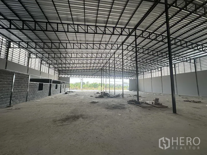 Warehouse for rent in Lam Luk Ka, Pathum Thani - Interior showing partial office block and ventilated upper panels that bring in natural light.