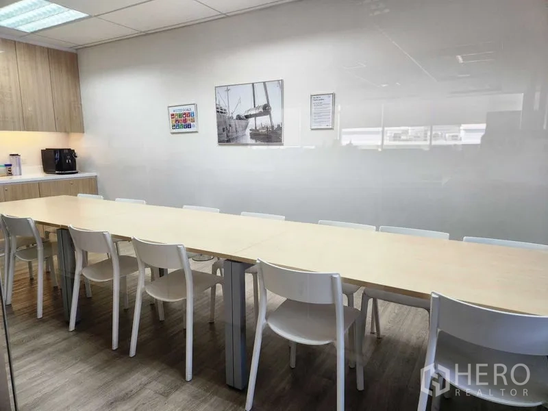 Office Space for rent - Pantry and break room featuring a long table, white chairs and built-in cabinets.