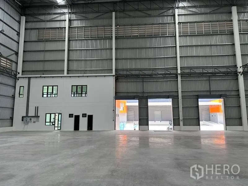 Factory for rent in Bang Phli, Samut Prakan - View from the production floor toward large shutter openings and an internal office block.