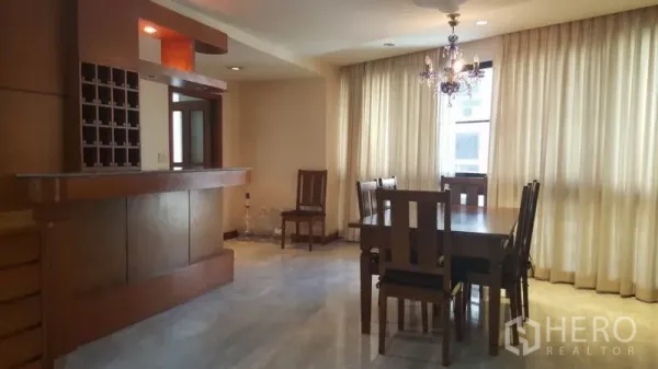 Condominium for rent in Khlong Toei, Bangkok - Spacious dining area with chandelier, large windows, and a built-in wooden bar at President Park condominium in Khlong Toei.