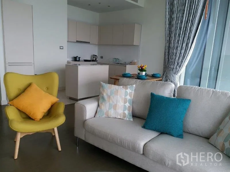 Condominium for rent in Pathum Wan, Bangkok - Open-plan living area with modern kitchenette, sofa and dining table in a bright Bangkok condo.