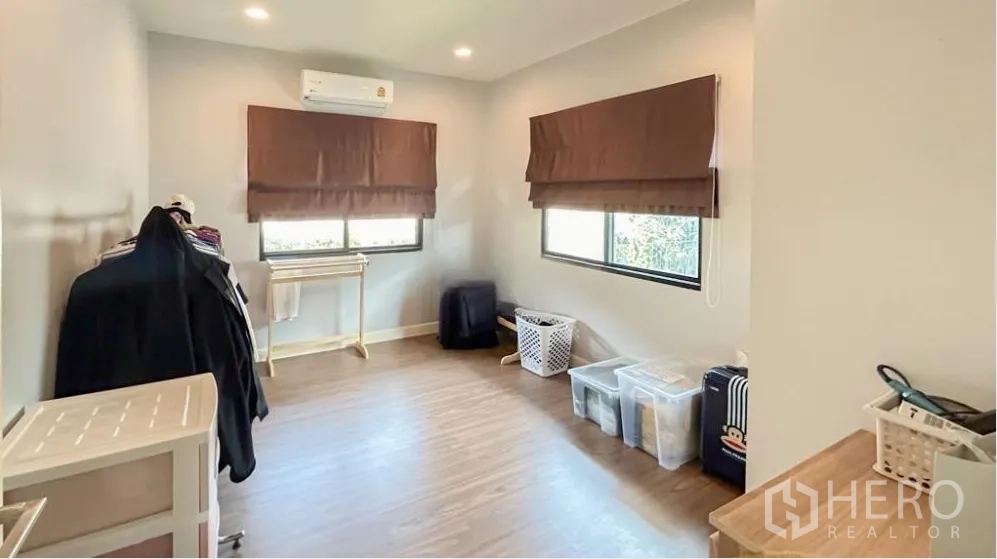 Detached House for sale in Lam Luk Ka, Pathum Thani - Third bedroom or multipurpose room with wood floors and two windows.