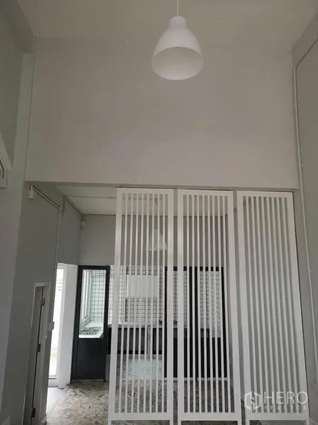 Townhouse for rent or sale in Din Daeng, Bangkok - Entrance hall with tall ceiling and white vertical slatted partition.