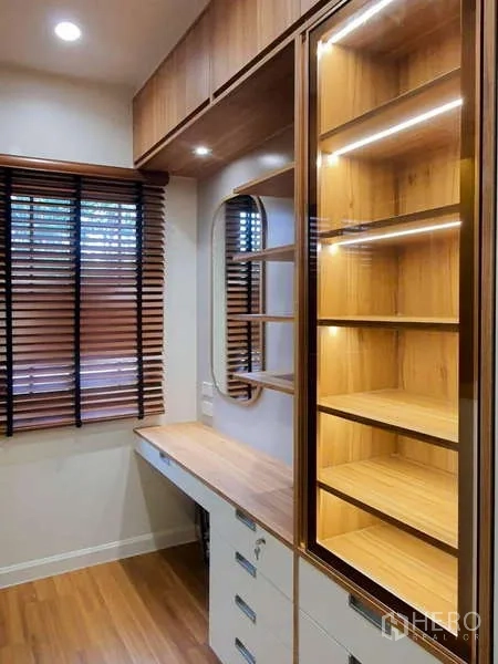 Detached House for rent in Sathon, Bangkok - Custom walk-in closet with illuminated display shelves and a dressing desk in wood finish.