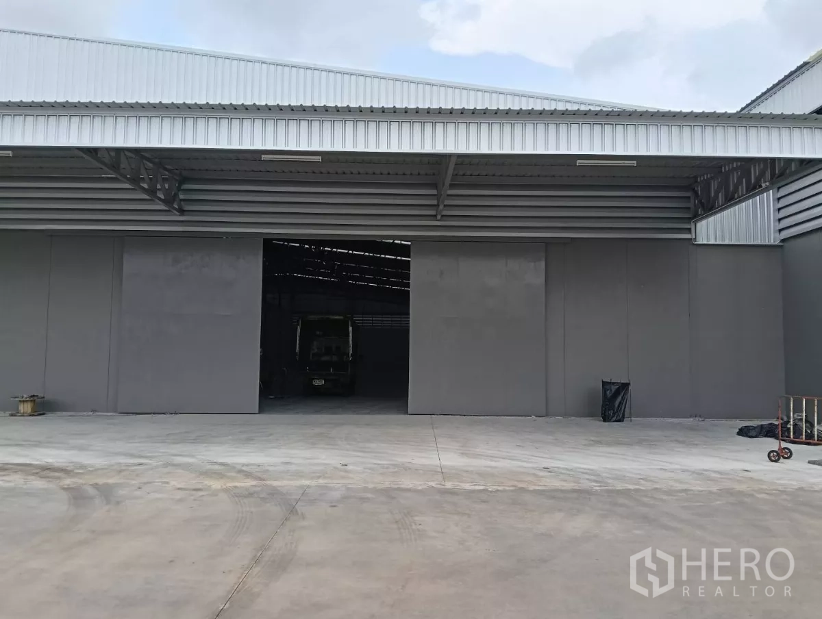 Warehouse for rent in Samut Prakan - Open loading bay with wide doors and a truck inside the warehouse on a spacious apron.
