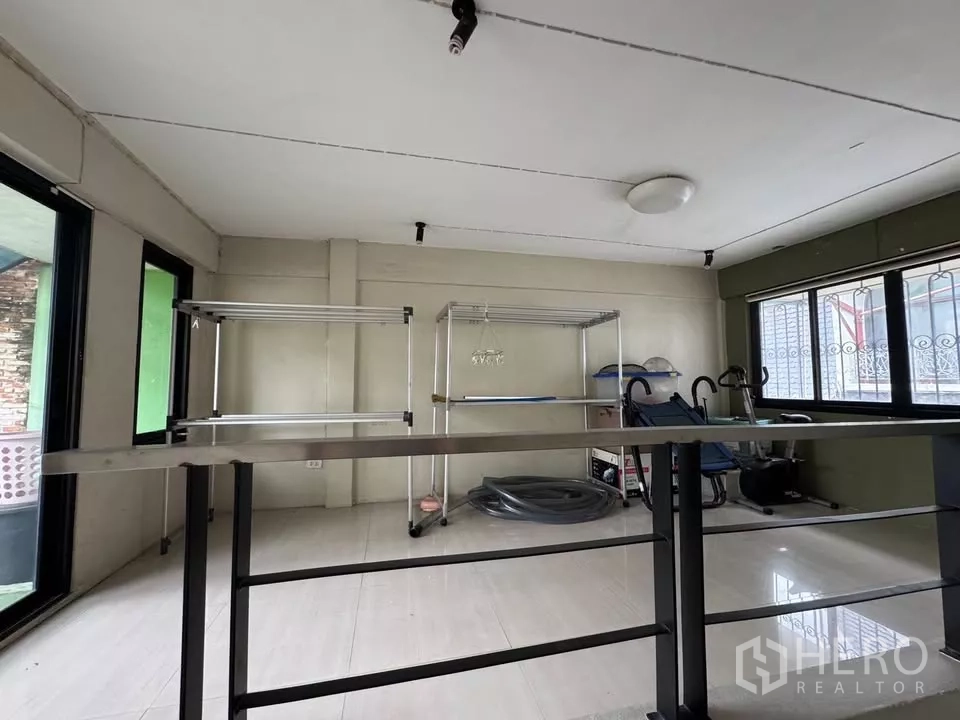 Shophouse for rent in Bang Rak, Bangkok - Bright open room with large windows, tiled floor, and stainless steel shelving units.