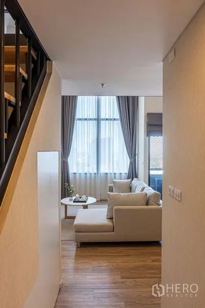 Condominium for rent in Khlong Toei, Bangkok - Entrance hallway with staircase to the loft overlooking the bright living space.