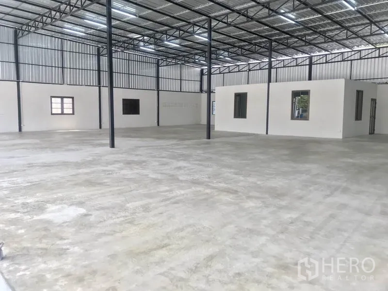Warehouse for rent in Pathum Thani - Spacious 1,000 sqm warehouse interior with high steel truss roof, polished concrete floor, and internal offices.