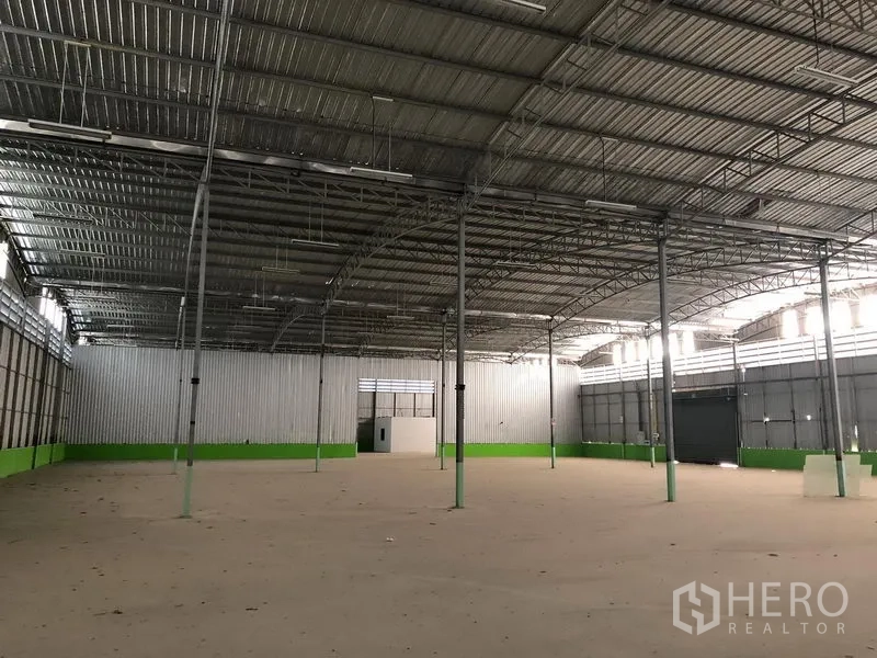 Warehouse for rent in Lat Krabang, Bangkok - Large clear warehouse bay with high ceiling, steel support columns and a rear service door.