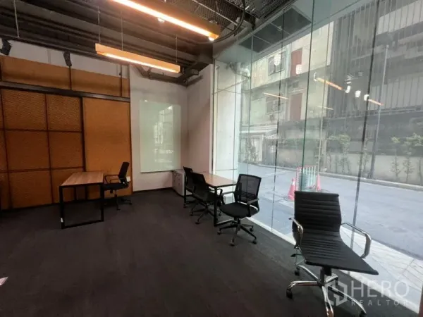 Office Space for rent - Bright office area with full-height glass frontage, desks, rolling chairs and a wall-mounted whiteboard.