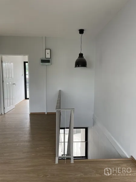 Home Office for rent in Khlong Toei, Bangkok - Upstairs landing with pendant light, wood flooring, and access to bedrooms