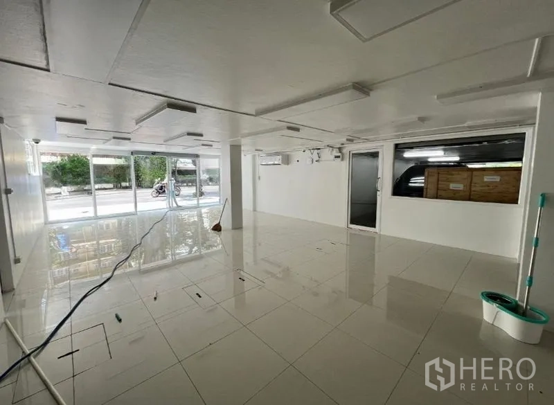 Retail Space for rent in Khlong Toei, Bangkok - Bright showroom area with full-height street-facing windows for display.