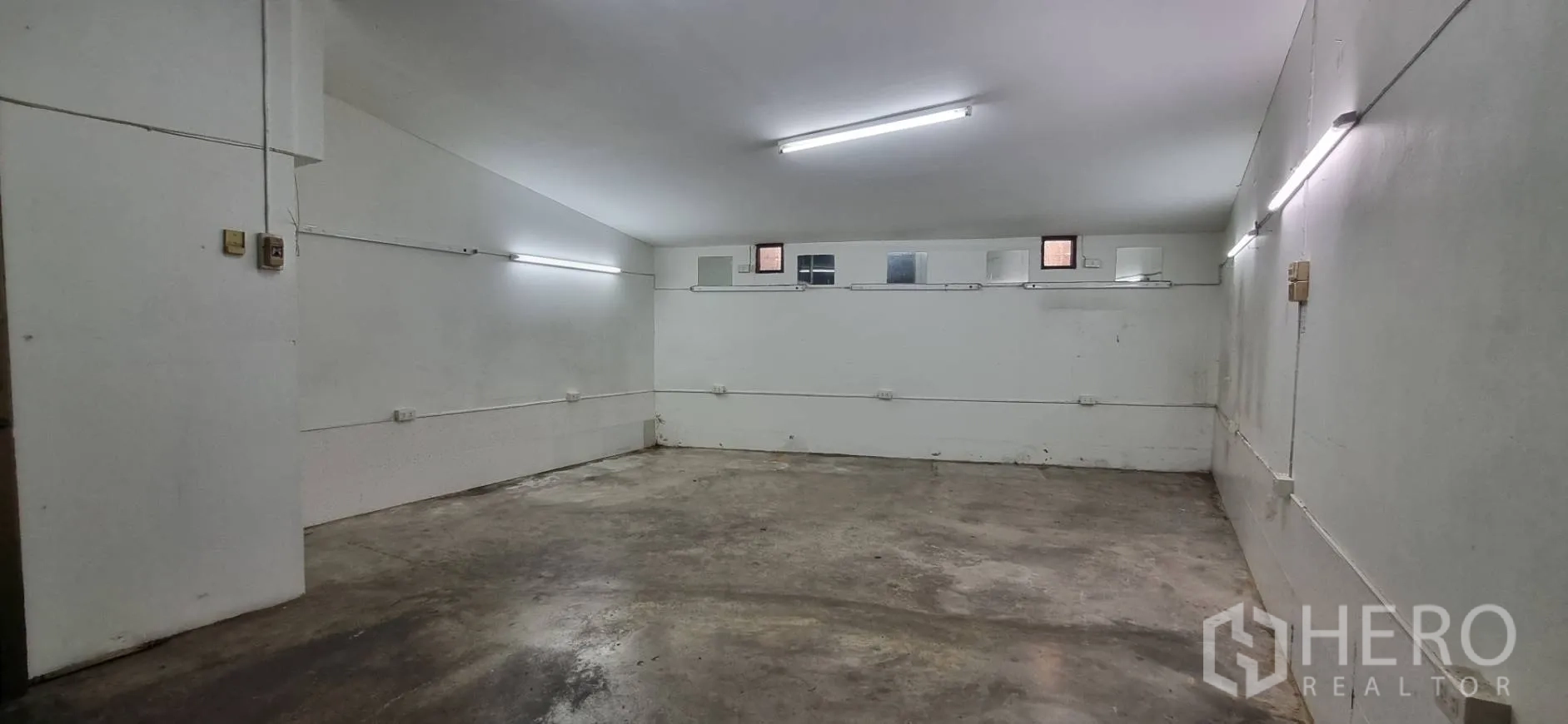 Shophouse for rent or sale in Bangkok - Basement or storage area with concrete floor and bright fluorescent lighting.