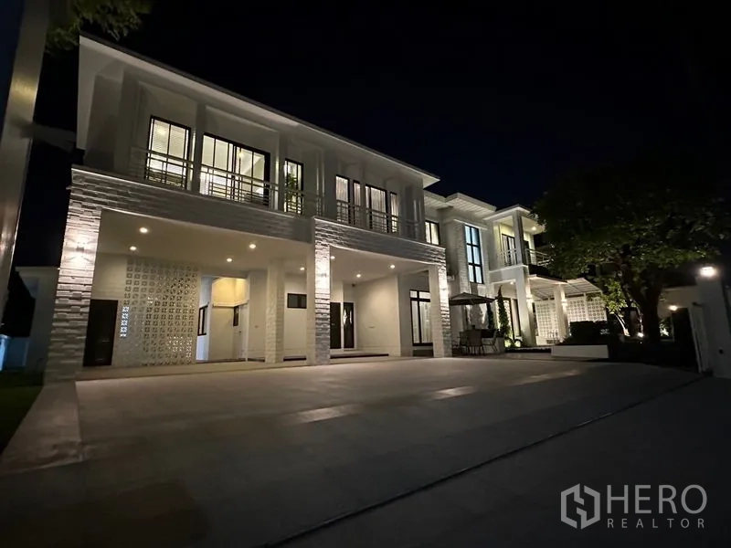 Detached House for rent - Night exterior of a two-storey modern detached house with wide driveway and lighting.